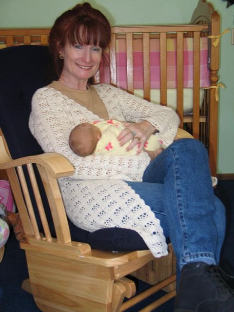 2003 Jeep TJ - Woman holding a baby in a rocking chair with a crib behind them.