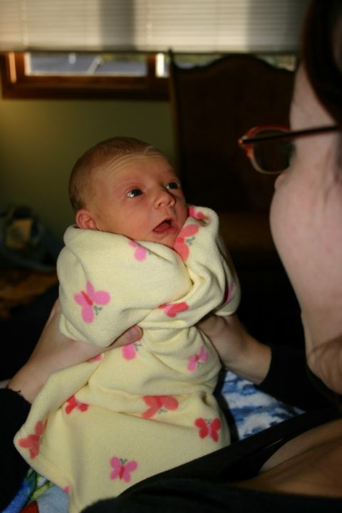 2003 Jeep TJ - A person holds a swaddled infant, who looks up with an open mouth.