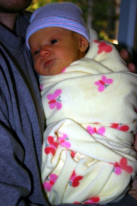 2003 Jeep TJ - A person holds a newborn baby swaddled in a butterfly-patterned blanket.