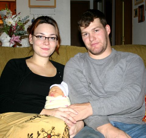 2003 Jeep TJ - A family is captured in a moment of tenderness, holding their newborn baby.