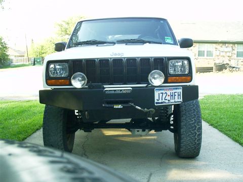 1983 Chevrolet Silverado 1500 - Front view of a white Jeep Cherokee XJ with an aftermarket bumper and auxiliary lights.