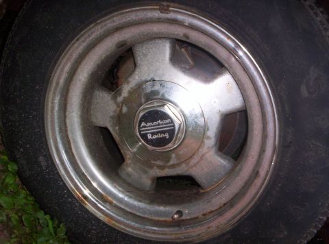 1973 Ford Ranchero - This is a close-up of an American Racing wheel with a tire. The wheel has a five-spoke design and a center cap with the brand name.