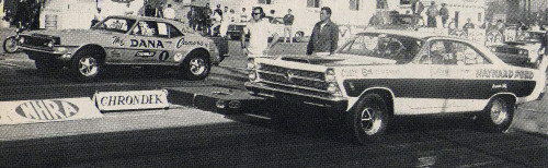 Two 1960s drag cars launching at the starting line, black-and-white photo