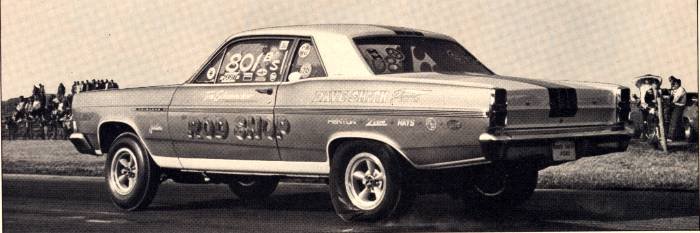 Vintage 1960s drag coupe, rear 3/4 view, 'ROD SHOP' lettering and mag wheels on strip
