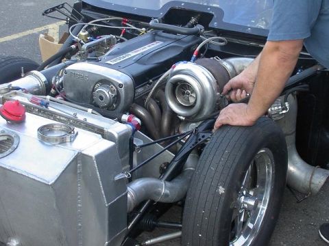 1990 Nissan Sentra - Mechanic works on a turbocharged Nissan RB26DETT engine, likely for a custom build.