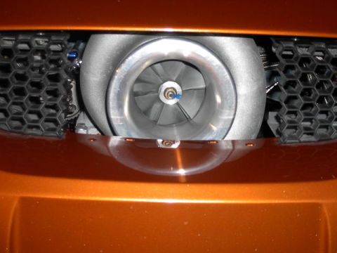 1990 Nissan Sentra - Close-up of a turbocharger visible through the honeycomb grille of an orange vehicle.