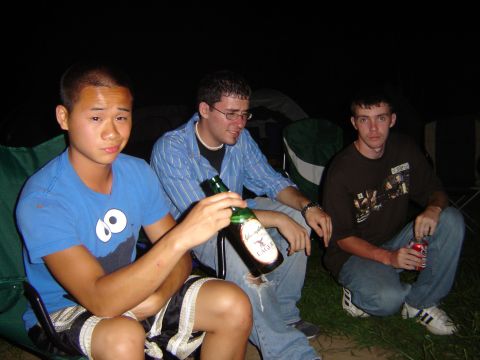 1995 Ford Probe - Three men are gathered outdoors at night, with one holding a beer bottle and another a soda can.