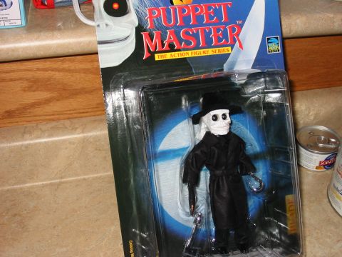 1991 Ford Bronco - A Puppet Master action figure is displayed in its original packaging on a countertop.