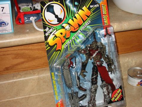 1991 Ford Bronco - A Spawn action figure is displayed in its original packaging, alongside other items on a countertop.