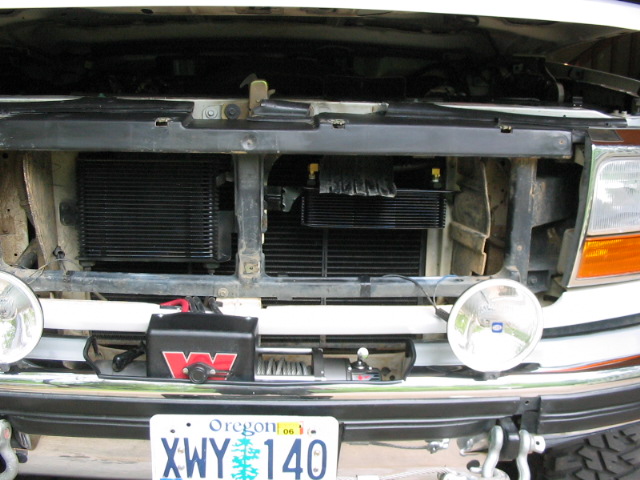 White Ford Bronco front with grille off showing coolers, round fog lights, Warn winch, and Oregon plate XWY 140.