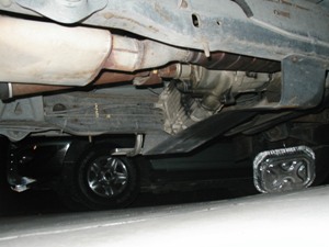 1989 Ford Bronco - The underside of a vehicle is shown, with another vehicle partially visible beneath it.