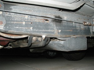 1989 Ford Bronco - Close-up view of the undercarriage of a vehicle, showing the frame and fuel tank.