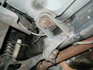 1989 Ford Bronco - Close-up view of the undercarriage, focusing on the suspension and exhaust system.