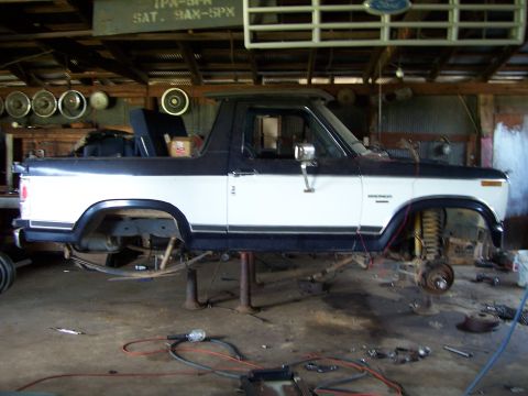 1983 Ford Bronco - This two-tone 1983 Ford Bronco is shown in a garage, elevated on hydraulic lifts for maintenance.
