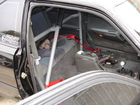 1989 Mazda MX-6 - Interior view of a modified 1989 Mazda MX-6, a roll cage and racing harness.