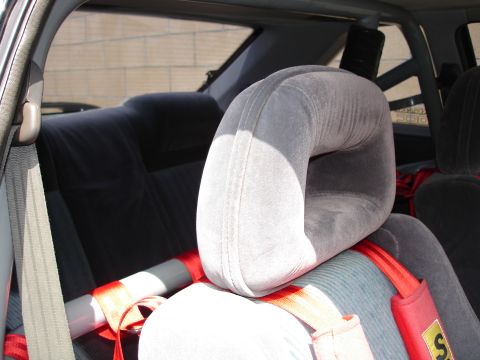 1989 Mazda MX-6 - Interior shot showing gray seats, red racing harnesses, and a roll cage, suggesting a modified vehicle.