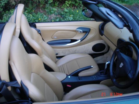 2001 Porsche Boxter - Interior view of a convertible with tan leather seats and door panels, showing the steering wheel and center console.