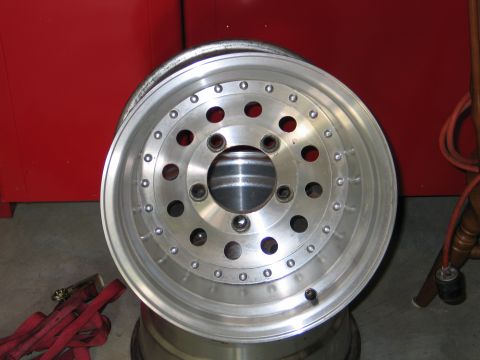 1992 Ford Bronco - A single aluminum wheel is shown, with visible bolt holes and a silver finish.