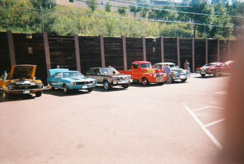 1972 Ford Ranchero - A collection of vintage automobiles are lined up in a parking lot on a sunny day.