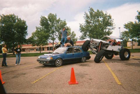 1972 Ford Ranchero - A blue sedan with people on its roof is positioned next to a custom off-road buggy with the number 70 visible.