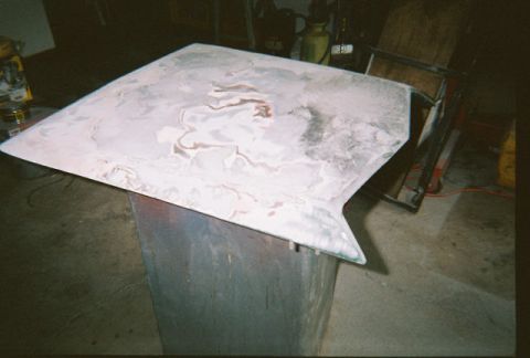 1972 Ford Ranchero - Car hood undergoing bodywork, showing patches of filler and primer.