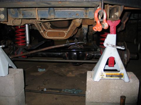 1995 Ford Bronco - Vehicle's undercarriage and suspension components are visible while supported by jack stands.