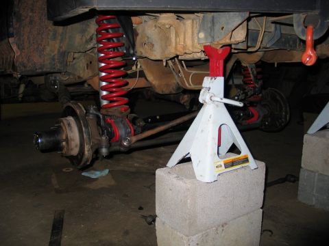 1995 Ford Bronco - The vehicle's undercarriage is supported by jack stands as its suspension is worked on.