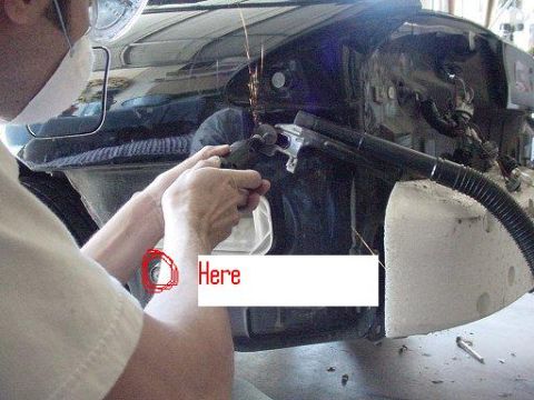 1993 Ford Probe - A person is using a grinder on the body of a car, with sparks flying. The interior and engine bay are exposed.