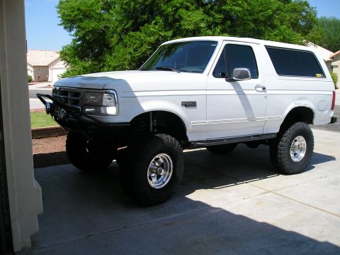 1993 Ford Bronco - This lifted 1993 Ford Bronco features an aftermarket front bumper and aggressive off-road tires, giving it a commanding presence.