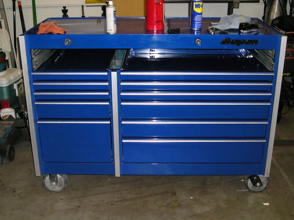 Blue Snap-on rolling tool chest in a garage with WD-40 and cans on top