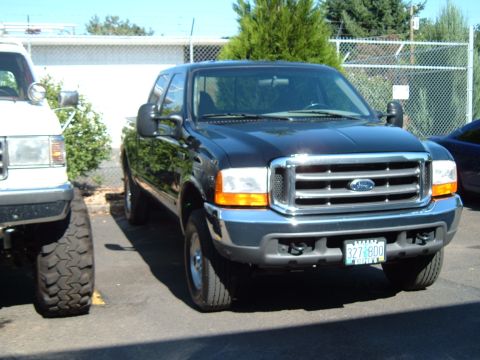 2000 Ford F-250 - Front view of a black 2000 Ford F-250 pickup truck, a prominent chrome grille and a visible license plate.