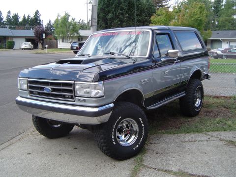 1989 Ford Bronco - This lifted 1989 Ford Bronco features a two-tone paint scheme and an aftermarket hood scoop.