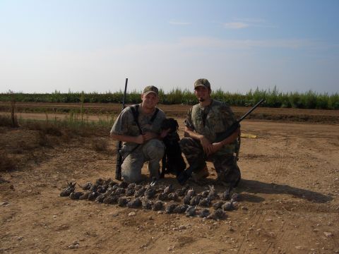 1990 Ford Bronco - Hunters pose with their dog and a successful bird hunt, with a field in the background.