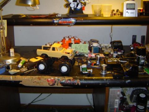1979 Ford Bronco - A model of a 1979 Ford Bronco sits on a workbench surrounded by hobby supplies and other model parts.
