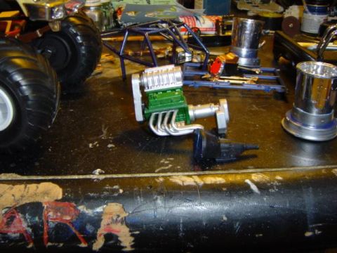 1979 Ford Bronco - Model engine and chassis components laid out on a workbench, possibly for assembly.