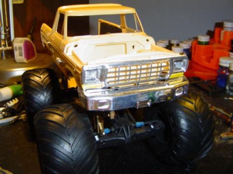 1979 Ford Bronco - Model 1979 Ford Bronco with oversized tires sits on a workbench with craft supplies in the background.