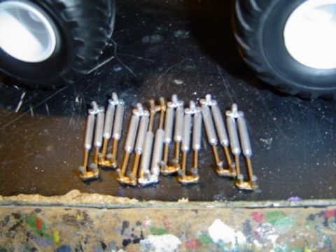 1979 Ford Bronco - Model car shock absorbers and tires are shown on a workbench surface.