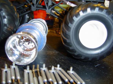 1979 Ford Bronco - Several parts for a large-scale RC monster truck are visible, including tires, rims, and shock absorbers.