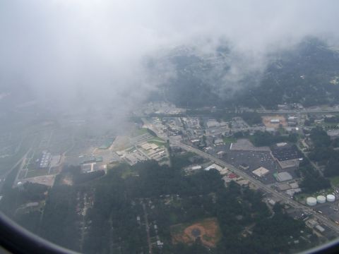 1979 Ford F-150 - An aerial perspective captures a town amongst trees, with clouds drifting overhead.