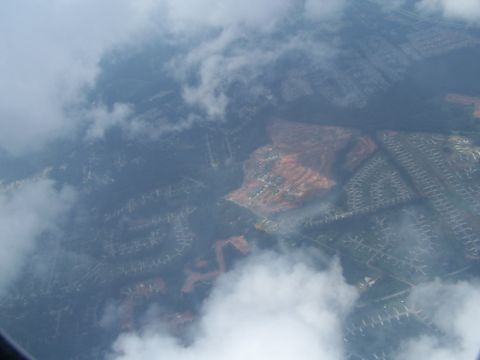1979 Ford F-150 - An aerial perspective shows residential areas and construction zones partially obscured by clouds.