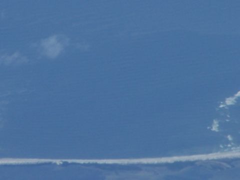 1979 Ford F-150 - A wide expanse of blue sky is visible, marked by a distinct horizontal cloud streak and scattered smaller clouds.