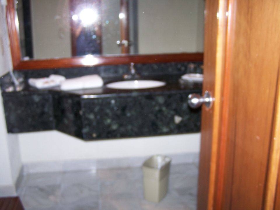Bathroom vanity with dark green granite countertop and white sink