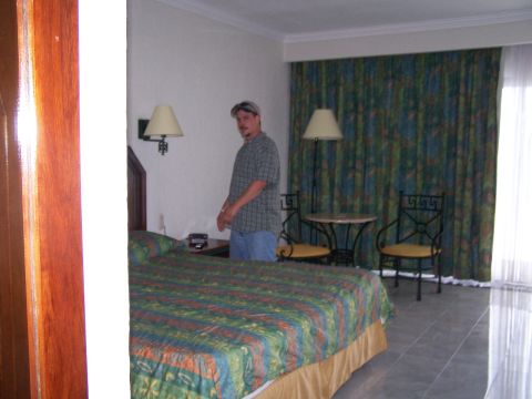 1979 Ford F-150 - Interior view of a hotel room a bed, a man, and decorative curtains.
