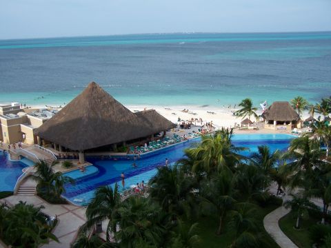 1979 Ford F-150 - A tropical resort features a large swimming pool and bar area adjacent to a sandy beach and the ocean.