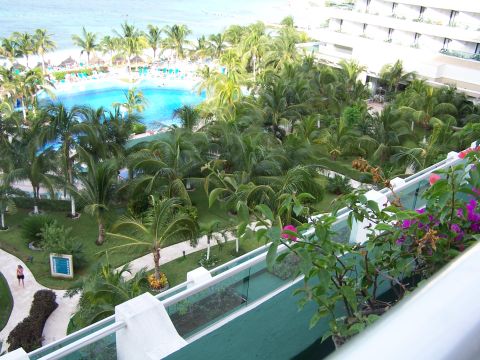 1979 Ford F-150 - A tropical resort scene shows a pool, beach, and hotel buildings surrounded by lush palm trees.