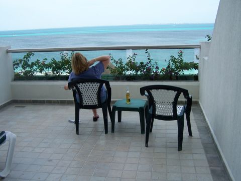1979 Ford F-150 - A person relaxes on a balcony with a view of the ocean and a bottle of beer on the table.