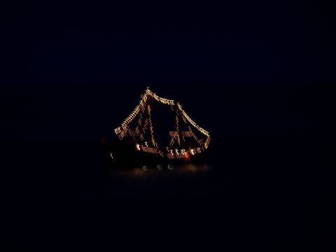 1979 Ford F-150 - A boat illuminated by string lights creates a blurry, festive scene on dark water.