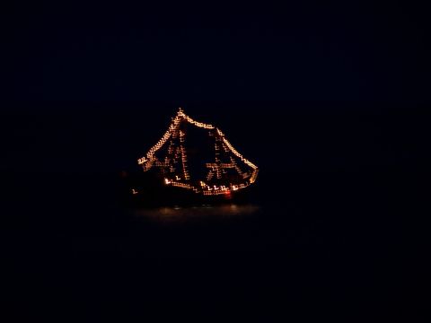 1979 Ford F-150 - A boat adorned with numerous lights is visible against a dark background.
