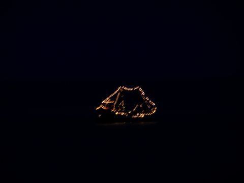 1979 Ford F-150 - A boat illuminated with lights spelling out 'Cancun' floats in dark water.