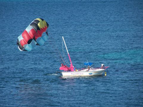 1979 Ford F-150 - A boat named Aquaworld is in the water with a parasail deployed.
